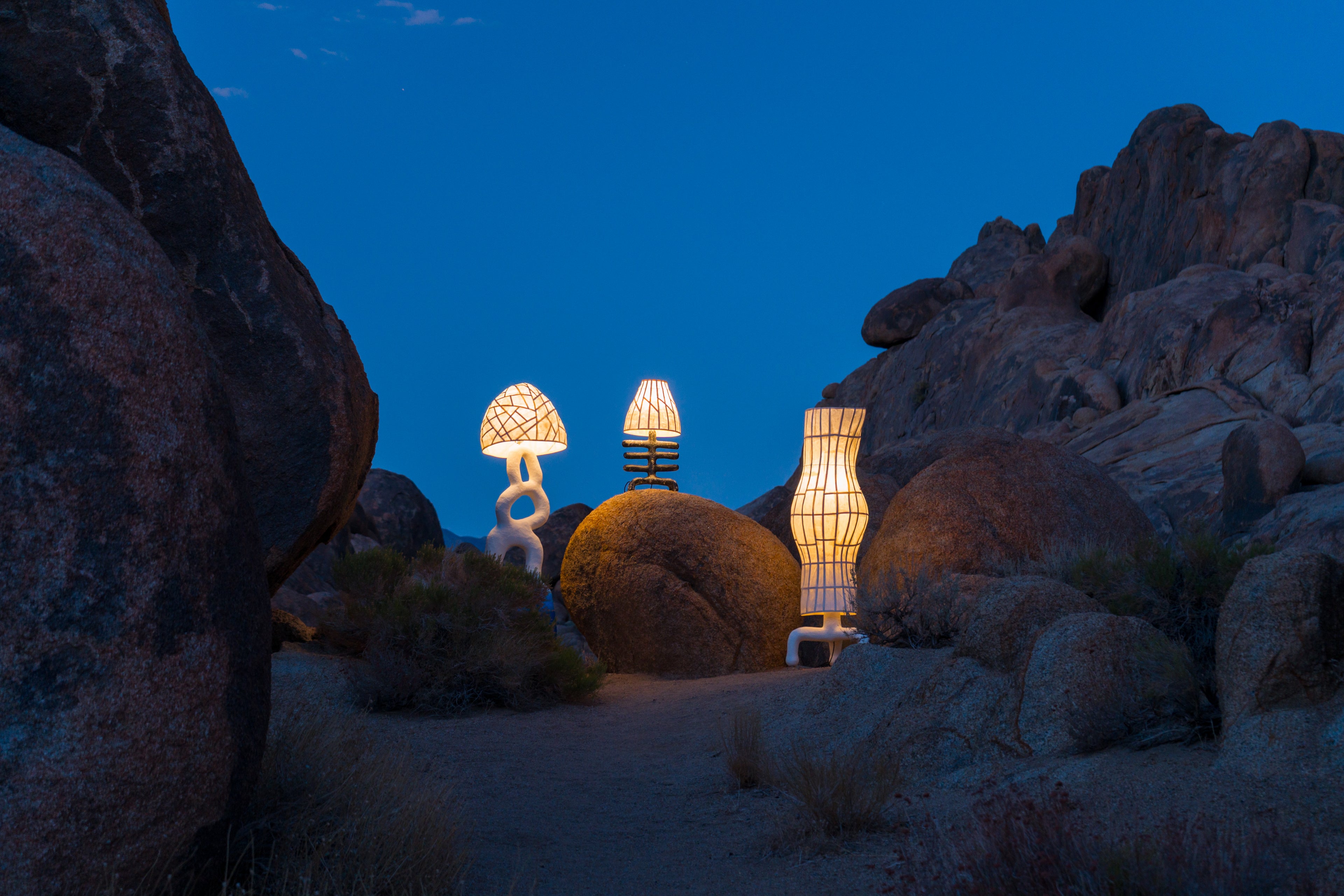 Decorative lamps on rocks against a dark blue sky