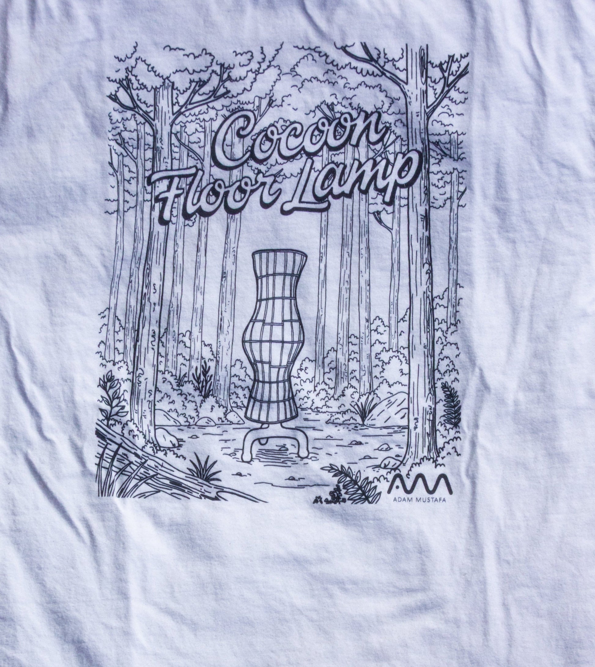 White t-shirt with black graphic design on grass