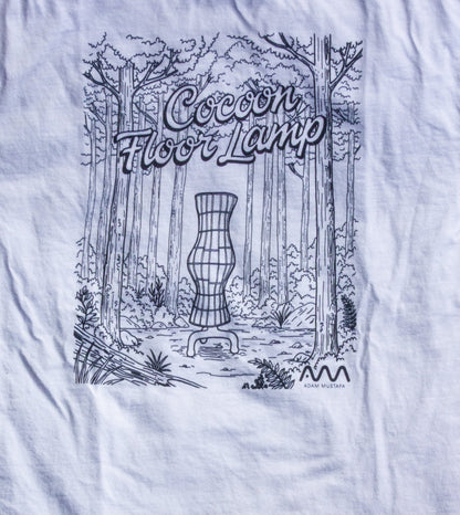 White t-shirt with black graphic design on grass